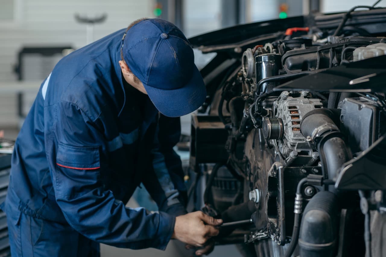 Diesel mechanic working under the hood of a truck